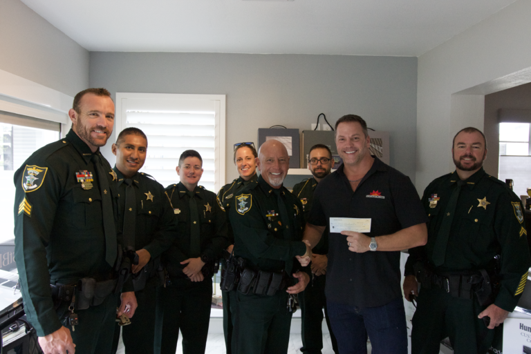 Lee County Police Department receives a check from SunCoast Blinds