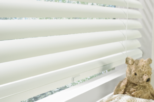 White Cordless Blinds with a teddy bear in the window sill
