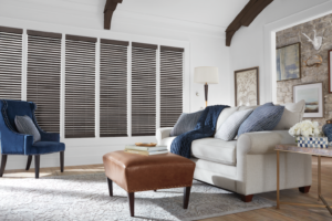 A living room with dark wooden blinds in windows