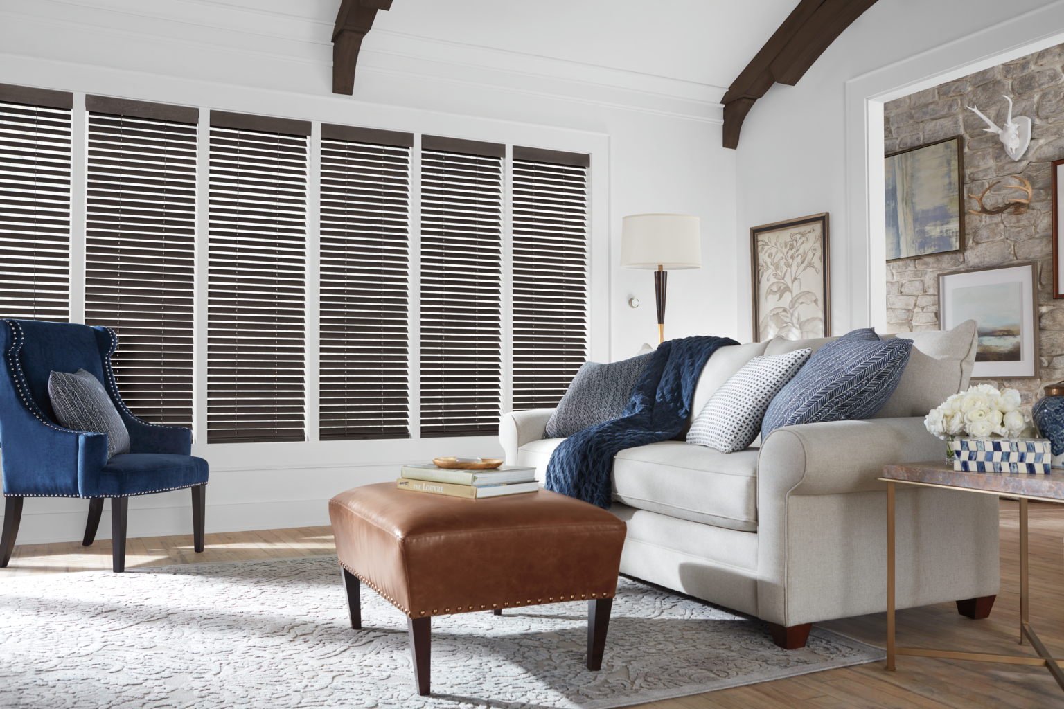 A living room with dark wooden blinds in windows